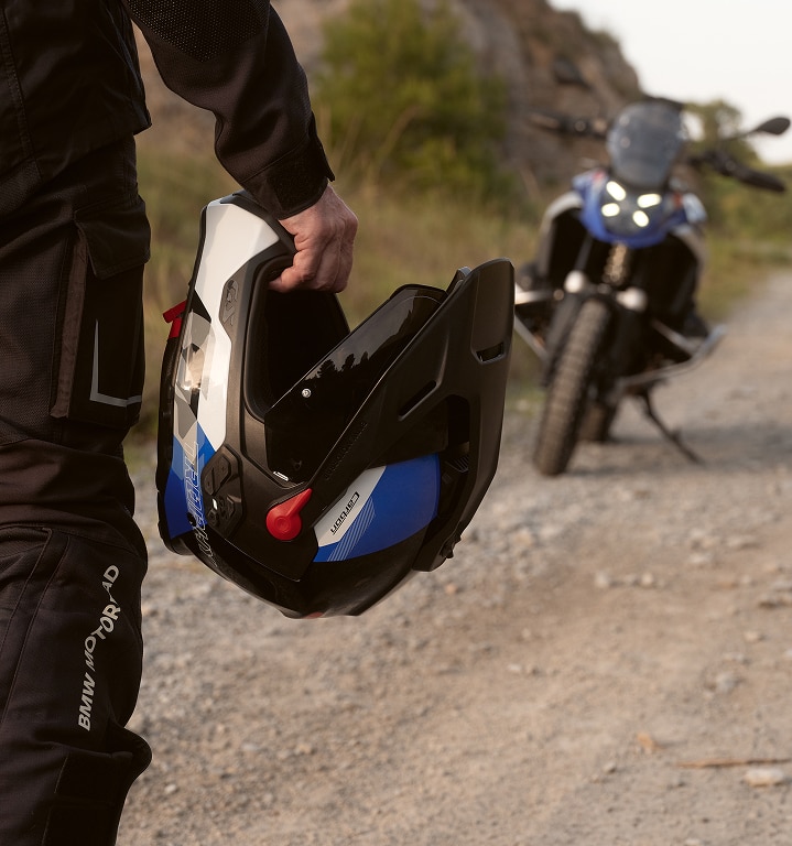 A person is holding a motorcycle helmet in their hand.